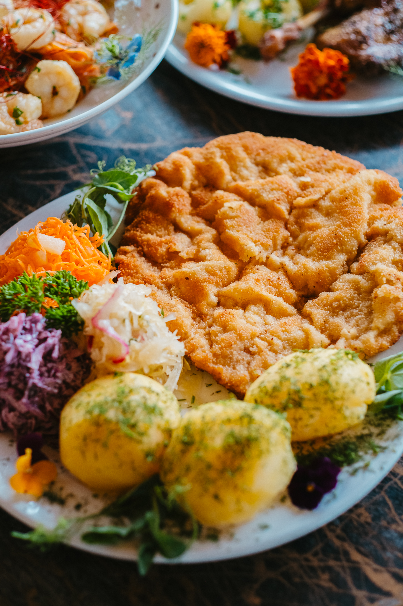 Duży kotlet schabowy z kluskami śląskimi i zestawem surówek